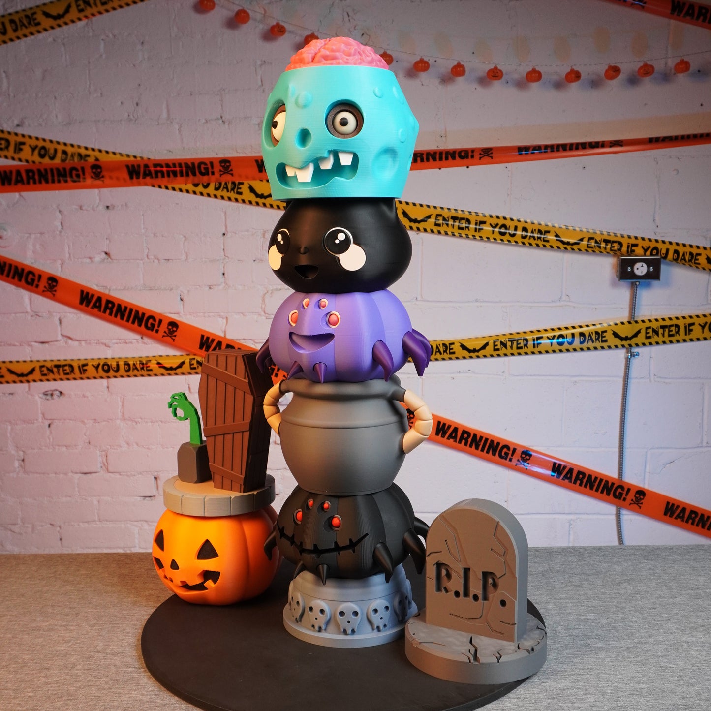 Halloween-themed toy stack with colorful characters and a pumpkin, surrounded by decorative tape.